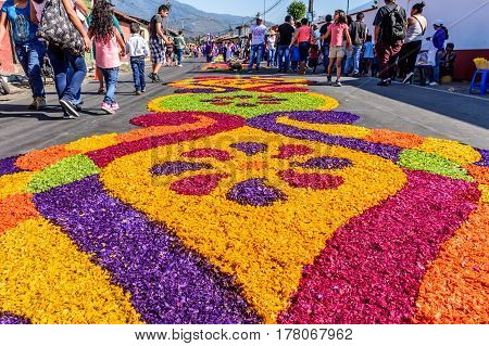 Antigua, Guatemala - March 19 2017: Locals make Lent carpets of dyed sawdust & flowers in path of religious procession in colonial town with most famous Holy Week celebrations in Latin America.