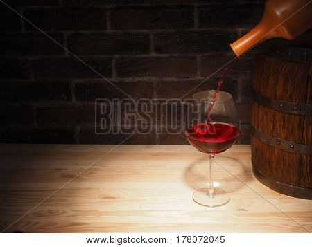 Glass Of Red Wine And Barrel On Wooden Table