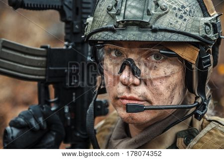 Norwegian Armed Forces Special Command FSK female soldier closeup portrait. Protective eye-wear and assault gun