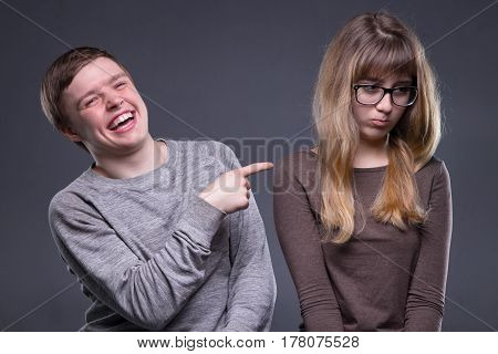 Sneering young man and woman on gray background