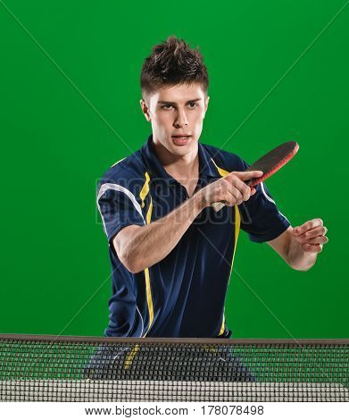 Young male athlete playing table tennis on green chromakey background