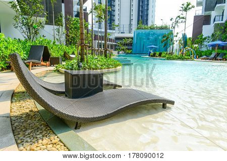 PATTAYA THAILAND - April 20 2016: Beach chairs in luxury swimming pool at tropical hotel resort relaxing and leisure time in the pool. Pattaya Thailand April 20 2016