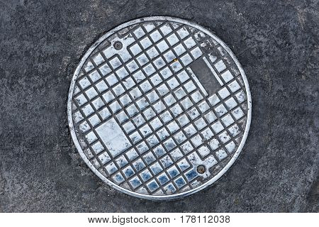 Circle old steel manhole cover on plublic street