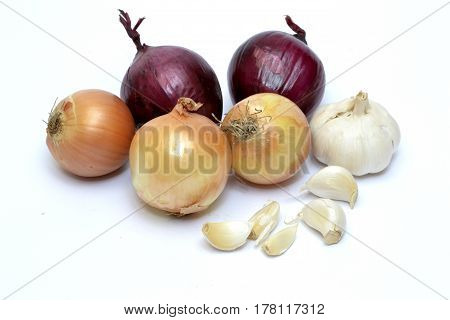Various species of onions and garlic on the white background