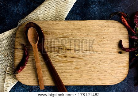 Rural kitchen board  With wooden spoons and old weave from above - grunge background with free text space. concrete background.  Different stuff. Top view. Copy space.