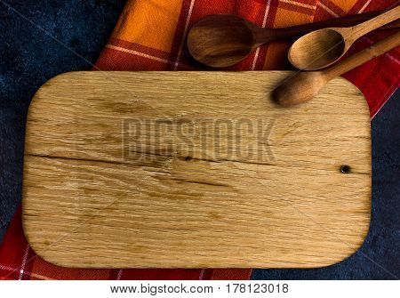 Rural kitchen board  With wooden spoons and old red cloth from above - grunge background with free text space. concrete background.  Different stuff. Top view.