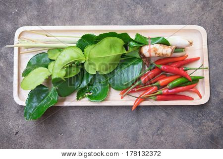 Thai Tom Yam soup herbs and spices lemongrass kaffir lime leaves galangal and chilli in tray wood