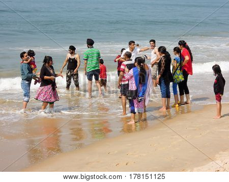 Indian Tourists Dangling Them Feet On The Beach Of Candolim