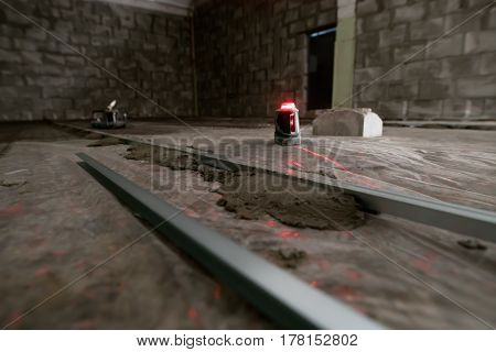 Electronic floor flatness meter with red light in studio being repaired