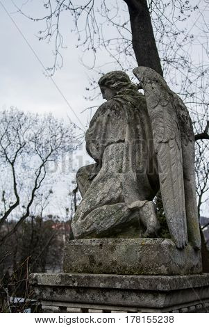 LVIV UKRAINE - JANUARY 6 2014: An old monument of angel at Lychakiv cemetery (Lviv Ukraine) on winter cloudy day.
