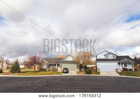 Puffy clouds over modern homes in a cul de sac in a suburb in Boise Idaho USA.
