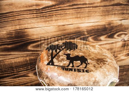 leather hand drum with the inscription Tunisia wooden background