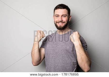 Portrait Of Happy Man Rise Up Hands And Successful Achievement Of Goals On Grey