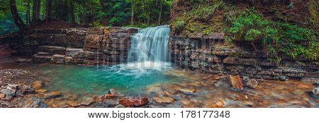 Evening Manyavsky waterfall in forest. Carpathian mountains Ukraine.