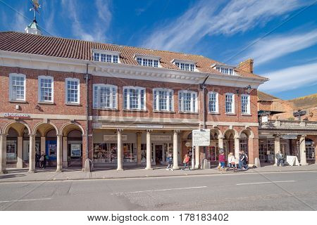 Farnham, UK. 25th March 2017. Pedestrians are walking along The Borough in Farnham on a sunny spring day.