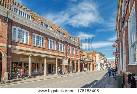 Farnham, UK. 25th March 2017. Pedestrians are walking along The Borough in Farnham on a sunny spring day.
