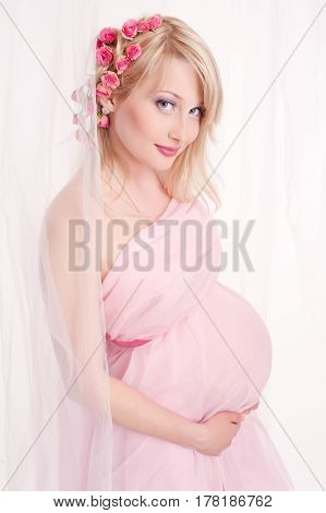 Photo portrait of a lovely young pregnant woman in a photo studio.