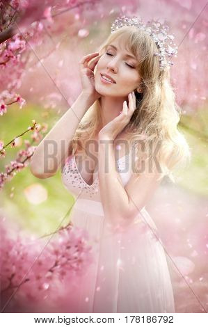 portrait of a beautiful blonde girl in a flowering garden