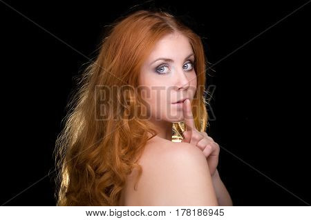 Hush .. beautiful red-haired girl on a black background