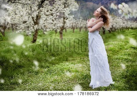 portrait of a beautiful blonde girl in a flowering garden