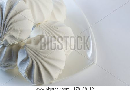 White vanilla marshmallows in a plate on a white background