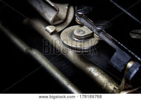 Hook & Wheel: Macro view of the sliding mechanism of a 1930's typewriter. Industrial look, large black areas, suitable for business and industrial advertising applications.