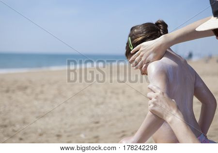 Mother applying sunblock cream to her daughter on face El Rompido Huelva Spain