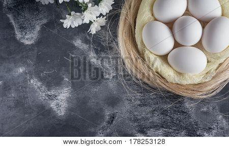 White Chicken Eggs In Easter Nest On Gray Background. Top View, Copy Space For Text