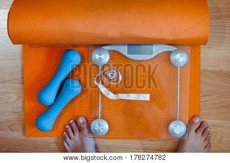 Weight scale healthy snack measuring tape and dumbbells on a table weight loss and sports concept flat lay