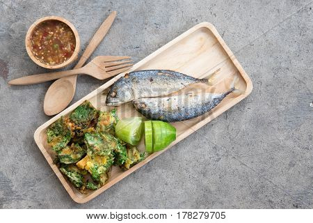 Thai local popular food as spicy shrimp paste dip (Nam Prik Kapi in Thai) served with fried mackerels sliced cucumber and fried acacia pennata omelet