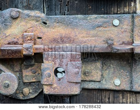 Detail of rusty iron door lock rusty old latch lever lock on a vintage wooden door