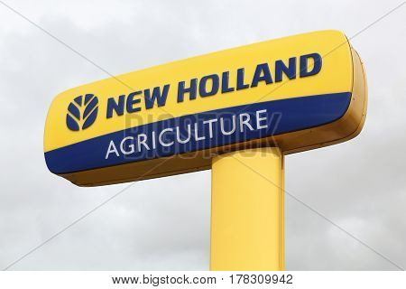 Chateaudin, France - March 19, 2017: New Holland Agriculture logo on a pole. New Holland is a brand agricultural equipment manufactured by CNH Industrial