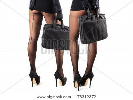Sexy female legs in beautiful stylish stockings and high heels shoes black gloves and dress holding business bag isolated on white background