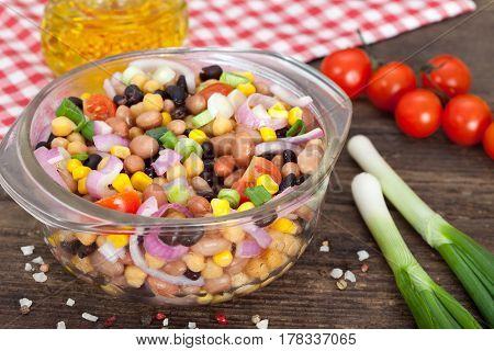 Three bean salad with sweetcorn, chickpeas and red onion in a vinaigrette dressing.