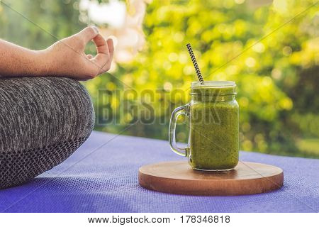 Closeup Of A Woman's Hands During Meditation With A Green Smoothies Of Spinach, Orange And Banana