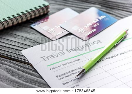 booking travel concept with insurance form and credit cards on gray wooden table background