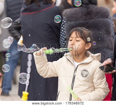 Shymkent, KAZAKHSTAN - 22 March 2017: People Celebrating the Kazakh holiday NARIYZ. Girl with soap bubbles .