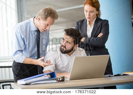 Mobbing, stress, work, scandal concepts. Angry boss man explaining his worker what to do first while woman posing with crossed hands and listening to him.