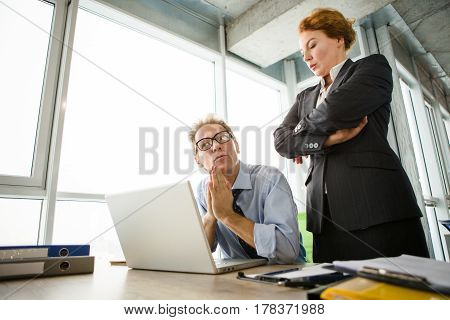 Mobbing, stress, work, scandal concepts. Low view of angry boss woman standing near her worker and listening to his explanations.