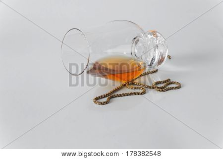 Single Malt Whiskey Glass With Gold Chain On A White Background