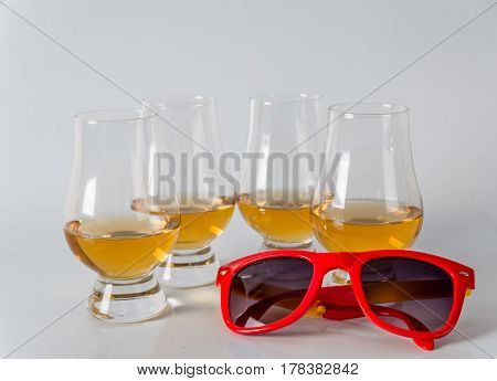 Delicious Single Malt Whiskey Glass With Sunglasses On A White Background