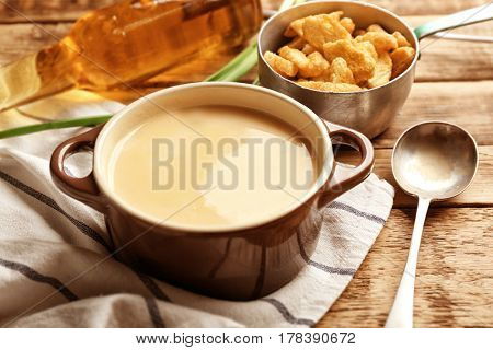 Delicious beer cheese soup with croutons on table