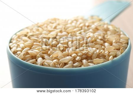 Measure scoop with brown rice closeup