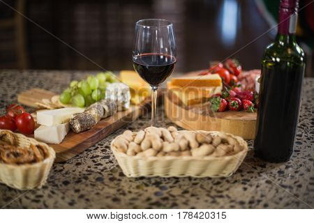 Wine bottle with a glass and a buch of food in a bar