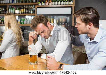 Tired man holding head in hand in a bar