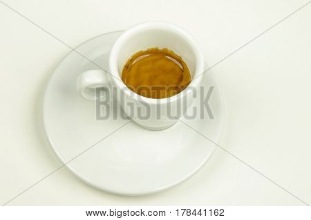 View of a white porcelain cup with espresso coffee with cream isolated on white background