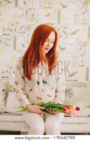 red-haired girl holding a bouquet of tulips