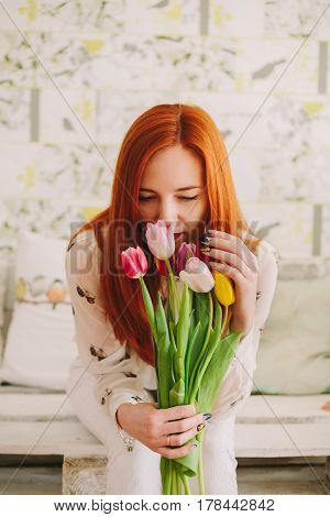 red-haired girl holding a bouquet of tulips