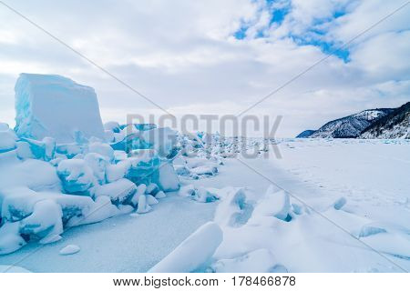 Row of ice blocks and the mountain covering with snow at lake Baikal in Russia in the winter