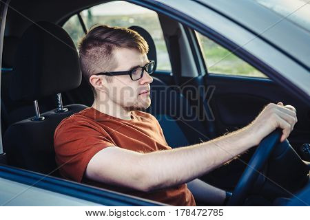 Attractive young man driving his new car.